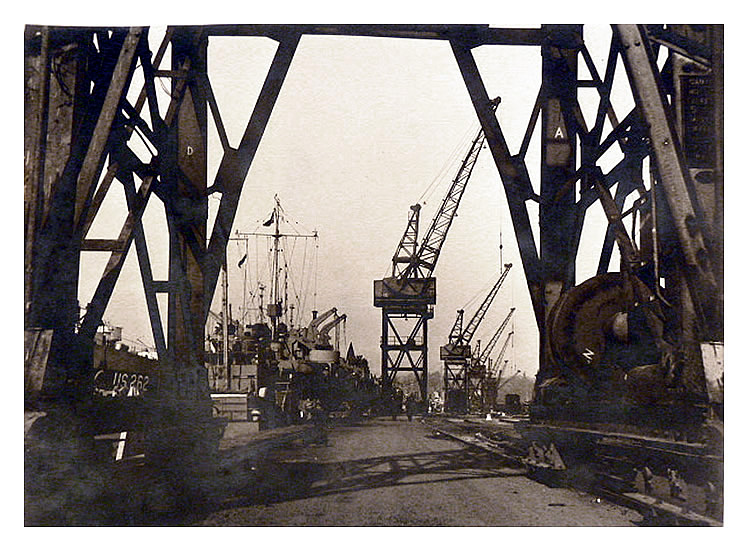 1943-4 - Back at the northern quay of the Penarth Dock and a view through a crane at LST US-262 awaiting the call to duty. 
