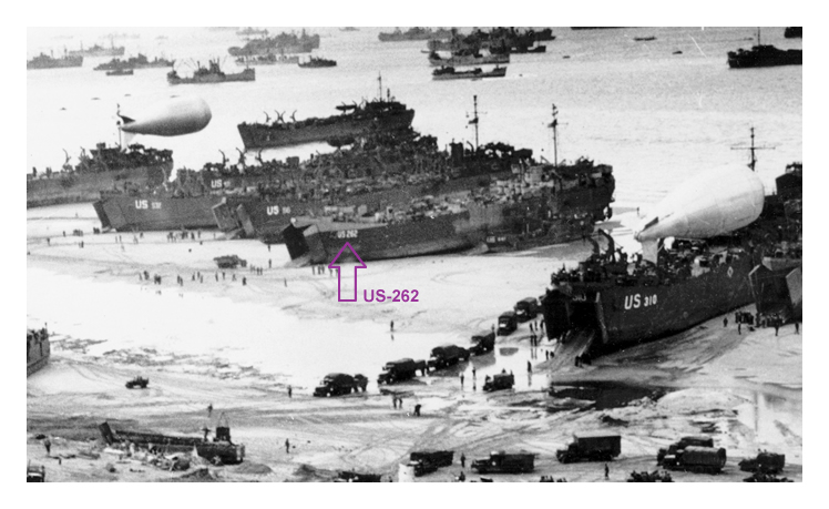 US-262 - part of an photograph of landing ships putting cargo ashore on one of the invasion beaches at low tide during the first days of the Normandy Invasion operation of June 1944.