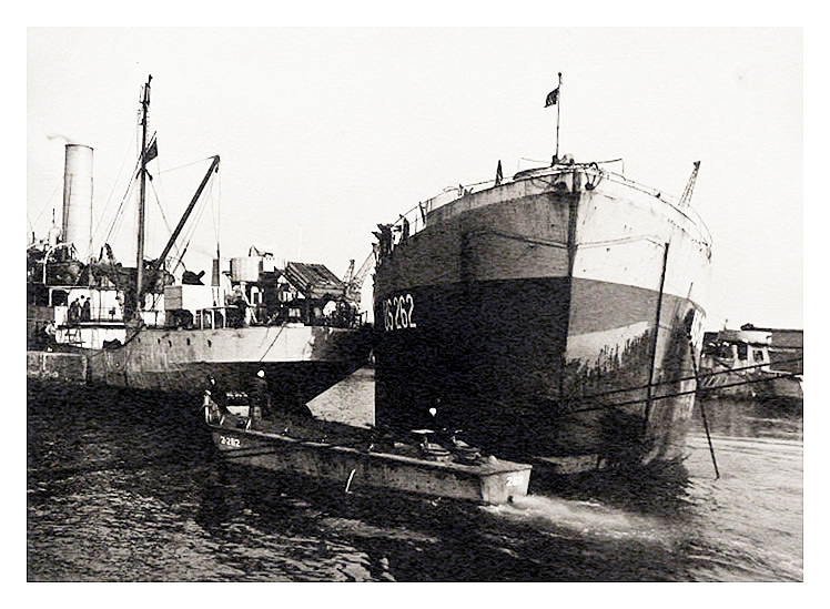 1943-4 - A photograph of LST US-262 at anchor apparently in contact with the stern of freighter at Penarth Dock.