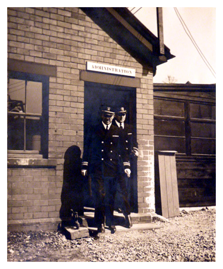 1943-4 - A view showing two U.S. Navy officials leaving the administration building at Penarth Dock. 