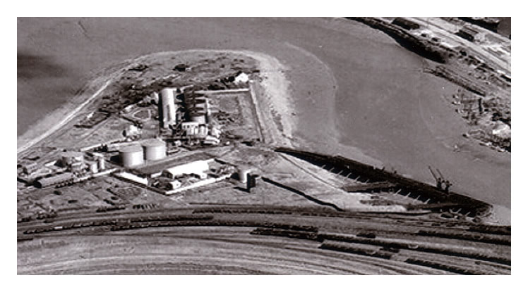 1949-1950 - An aerial view of the location of the former iron-ore wharf as re-purposed to the petroleum wharf with associated oil storage tanks and processing facilities. 